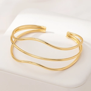 Detailed view of polished three-layer gold wave cuff bracelet with sleek metallic lines
