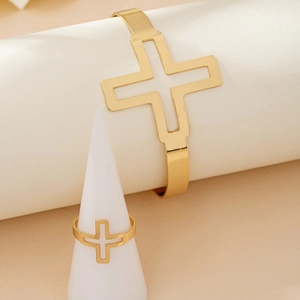 Elegant gold-tone cross motif open bangle and ring set displayed on jewelry stands