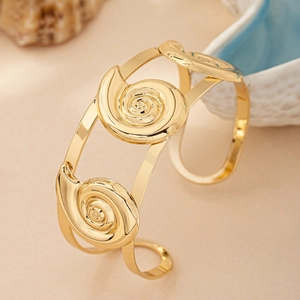 Golden double-layer cuff bracelet featuring conch shell spiral designs in a polished finish
