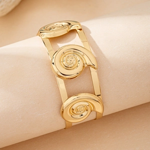 Gold wide open bangle featuring unique spiral conch shell motifs in a polished finish