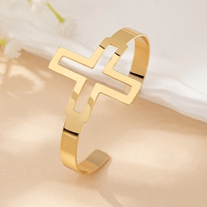 Detailed view of the large hollow cross design on this golden adjustable cuff bracelet