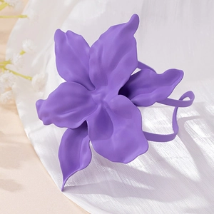 Detailed close-up of a matte purple floral accessory with layered 3D petals and soft fabric
