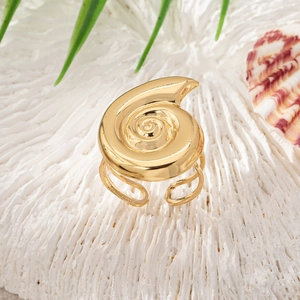 Adjustable golden spiral shell ring on white coral stone with marine aesthetics