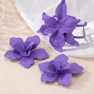 Dettaglio di accessori per capelli a fiore viola opaco su sfondo bianco morbido