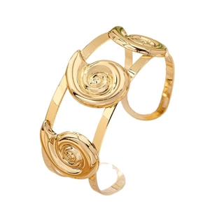 Polished gold cuff bracelet featuring spiral seashell motifs and a double-row open design
