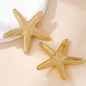 Macro detail of golden starfish earrings showing textured surface and secure back closure