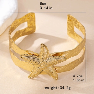 Golden starfish cuff armlet for women featuring wide hammered metal and beach holiday style