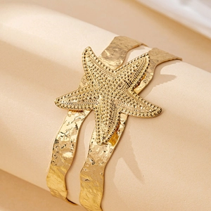 Golden starfish cuff bracelet with textured wave bands for summer beach vacations