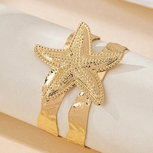 Golden starfish open cuff bracelet with detailed textured sea star on hammered metal band