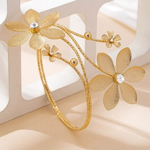 Detail of gold floral cuff bracelet with crystal inlays and matte woven texture