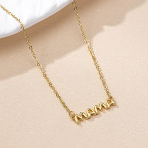 Minimalist gold MAMA letter pendant necklace on textured stone background for women