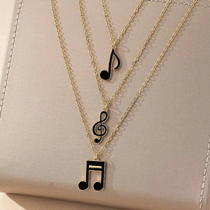 Ensemble de trois colliers notes de musique dorés avec pendentifs en émail noir