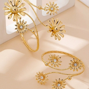 Two-piece golden daisy open cuffs with sparkling crystal centers and textured finish