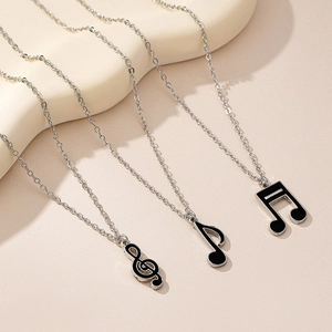 Vue détaillée des pendentifs notes de musique en émail noir sur colliers argentés