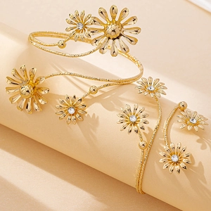 Golden daisy metal wire open bangles with clear crystal accents on a display