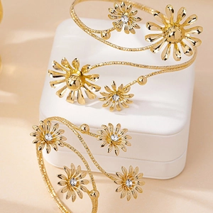 Two-piece daisy gold open cuff bracelets with sparkling crystals on white leather