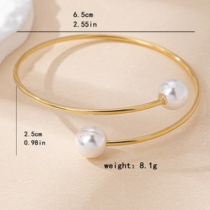 Bracelet jonc ouvert doré avec deux perles blanches et design élégant en spirale