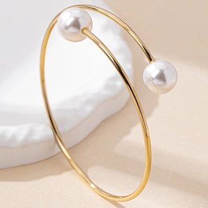 Bracelet jonc doré minimaliste orné de deux élégantes perles blanches rondes aux bouts