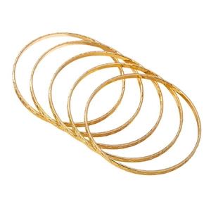 Set of six gold bohemian bangles with vintage engraved patterns on a white background