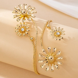Elegant gold daisy upper arm bracelet with sparkling crystals on a minimalist display