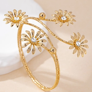 Detail of gold floral open bangle with sparkling sunflower accents and diamond texture