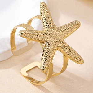 Portatovaglioli a forma di stella marina dorata con texture su sfondo beige caldo