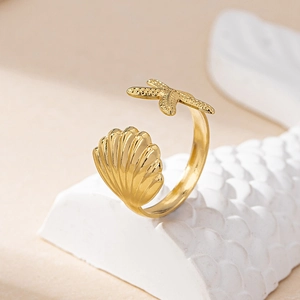 Detailed close-up of adjustable gold ring featuring starfish and seashell motifs