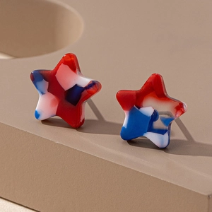 Macro detail of star earrings with red, white, and blue marble resin texture