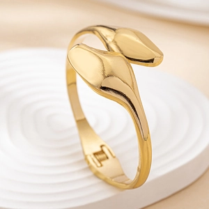Macro detail of golden snake-shaped bracelet showing the polished finish and hinge closure