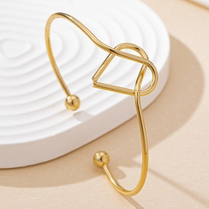 Détail macro du bracelet jonc doré géométrique avec contour de visage humain minimaliste