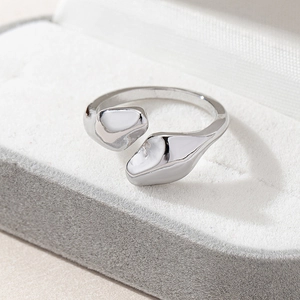 Detailed view of silver fluid snake ring with organic pebble shapes on jewelry display box