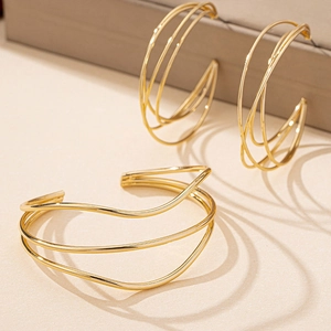 Minimalist gold geometric jewelry set featuring a layered bangle and matching earrings