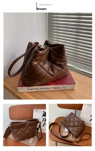Detail of a brown quilted puffer shoulder bag with elegant rhombic stitching and metal hooks
