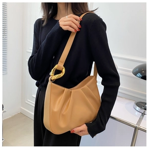 Detail of light brown pleated cloud bag featuring stylish irregular gold metal buckles
