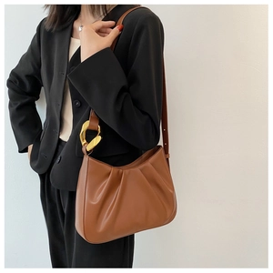 Close-up of brown pleated hobo bag with stylish large golden metal ring buckle detail