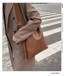 Detail of premium brown leather tote bag with wide strap and adjustable square buckle