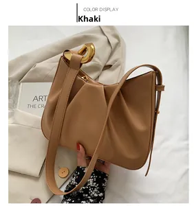 Detail of khaki cloud bucket bag with gold chain link and leather shoulder strap