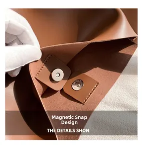 Macro detail of the magnetic snap closure and textured brown leather on a tote bag