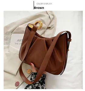 Brown leather pleated cloud bucket bag featuring chunky gold chain link hardware detail