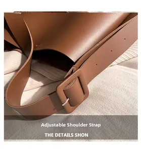 Close-up of adjustable brown leather shoulder strap with square buckle on tote bag