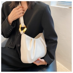 Chic cream ruched shoulder bag detail with large gold chain link on a black blazer