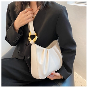 Detail of minimalist cream ruched bag featuring large gold geometric chain buckle link