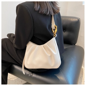 Detail of cream pleated cloud bag featuring a high-quality golden geometric metal buckle