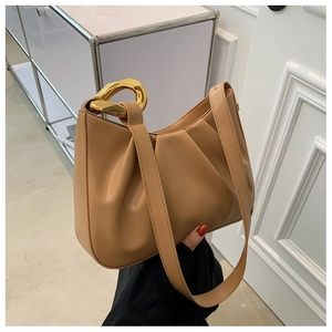 Close-up of khaki pleated bucket bag featuring chunky gold chain handle and slim strap