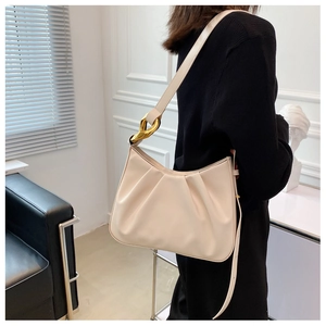 Detail of cream pleated cloud bag featuring premium gold chain strap buckle