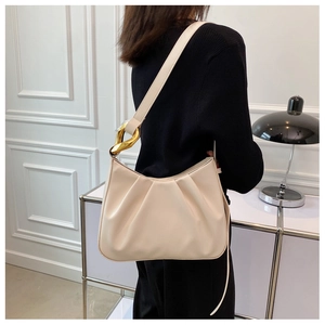 Detail of off-white ruched cloud bucket bag with stylish gold chain link hardware
