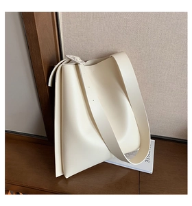 Detail shot of off-white minimalist tote bag in soft matte leather with wide shoulder strap