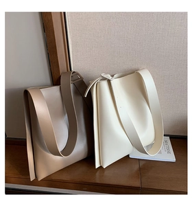 Detail view of large minimalist tote bags in cream and beige colors with wide straps