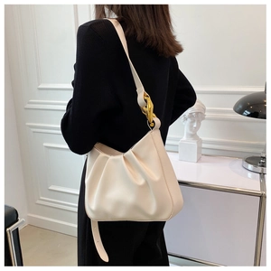Detail of creamy white pleated cloud bag featuring premium gold chain and PU leather texture