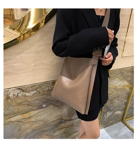 Detail of adjustable wide shoulder strap on a taupe leather tote bag for work